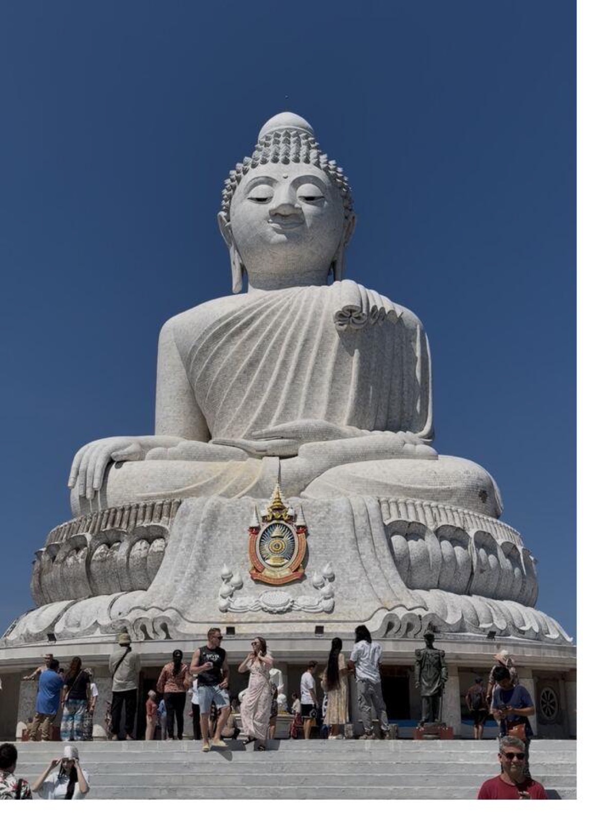 Visitors at the base of the Big Buddha statue in daylight