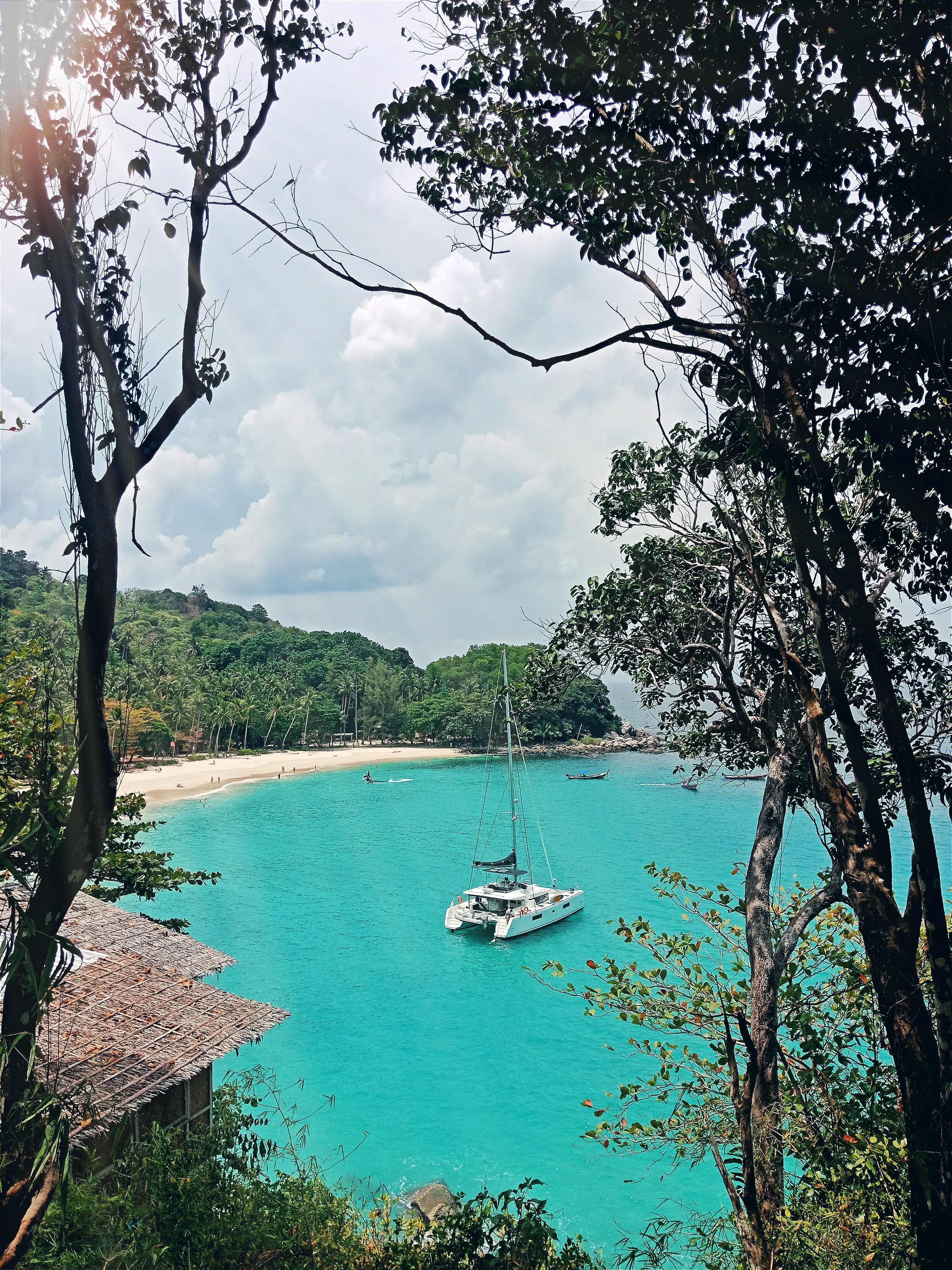 A boat anchored in a clear turquoise bay, Racha Island
