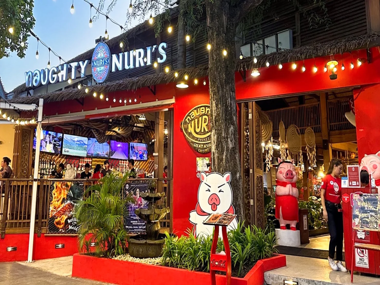 Naughty Nuri's restaurant storefront in Patong, with signature pig mascots