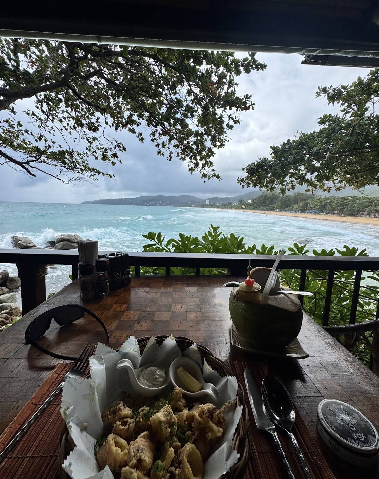 Table with seafood and a coconut drink overlooking the sea, On the Rock restaurant